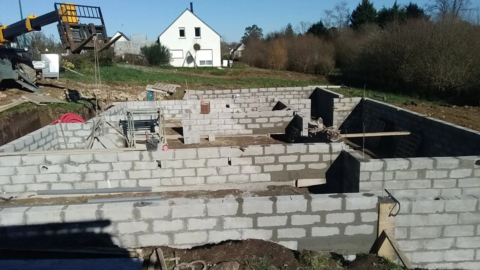 Chantier de maçonnerie : montage des murs en parpaings d'une construction neuve